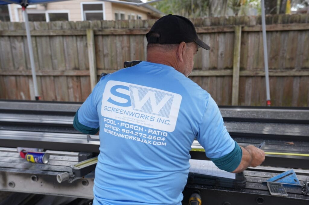 ScreenWorks technician preparing aluminum framing for a screen enclosure