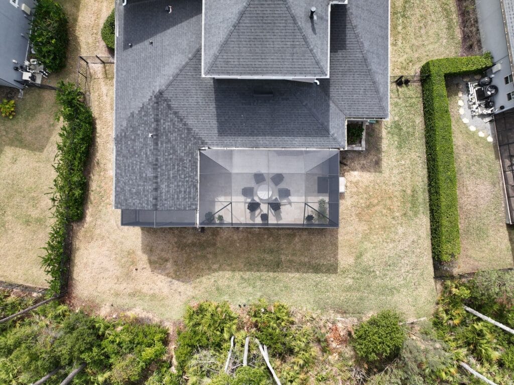 Aerial view of a screened patio enclosure behind a Northeast Florida home